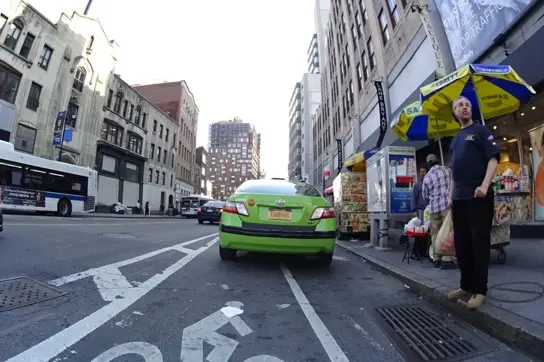 A green cab parked in a bike lane earlier this week